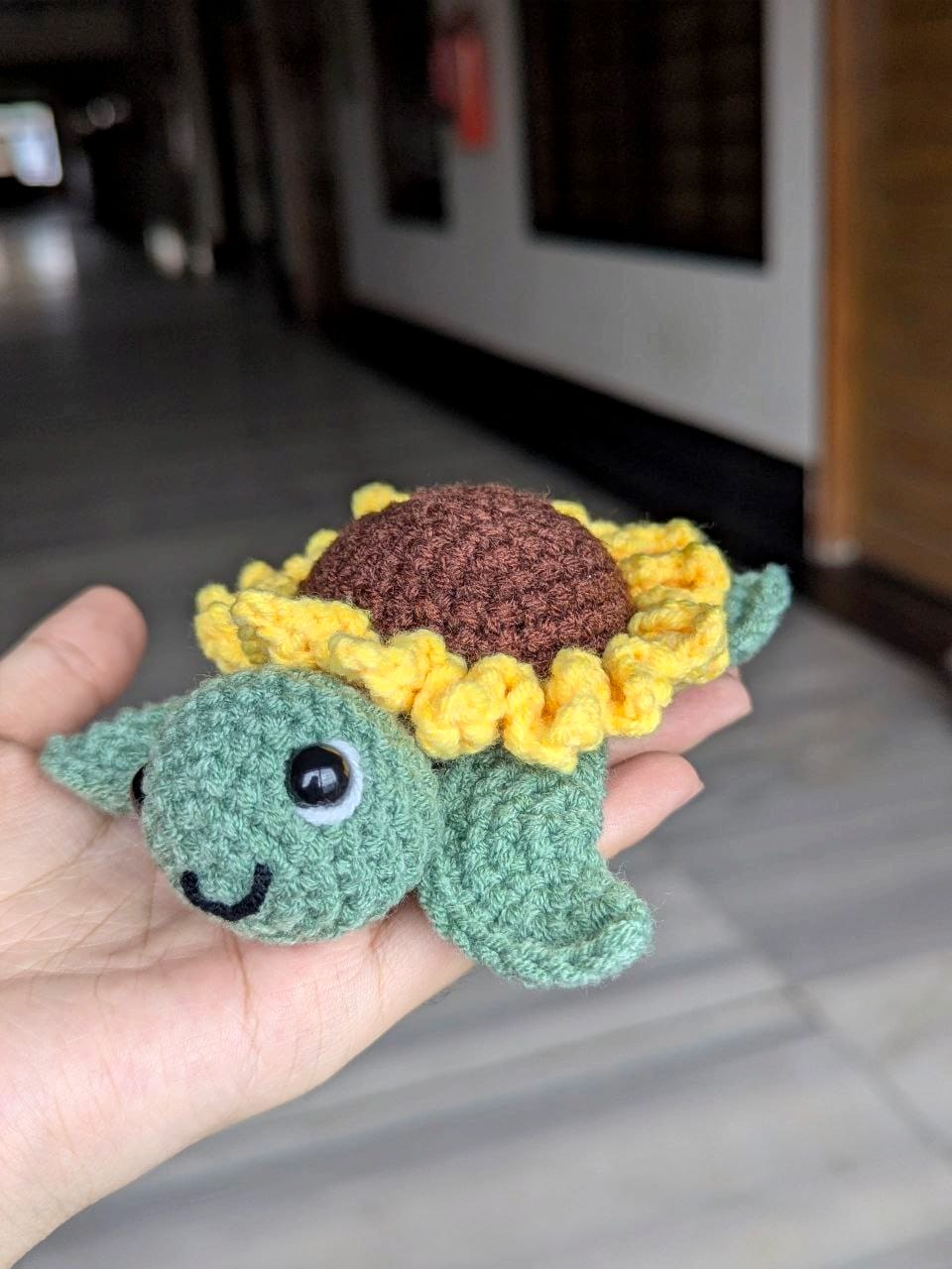Finished crochet sunflower turtle with a brown shell ringed by yellow petals