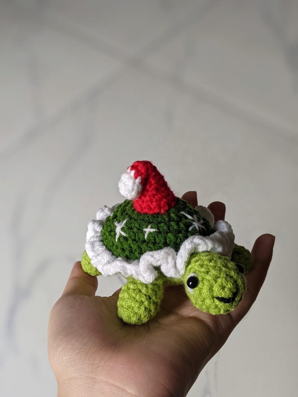 Finished crochet Christmas tortoise in a Santa hat, shown from a second angle