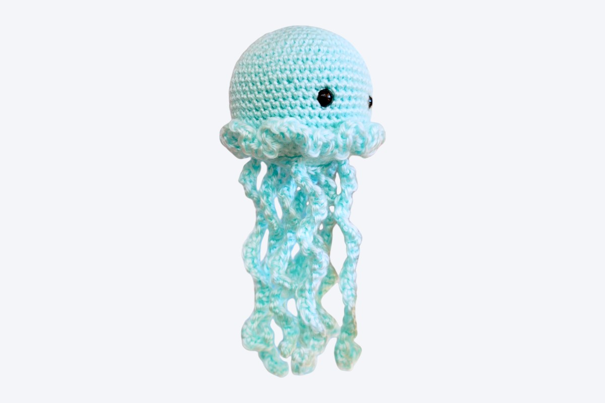 Pale mint crochet jellyfish made in one piece with a ruffled skirt and curling tentacles