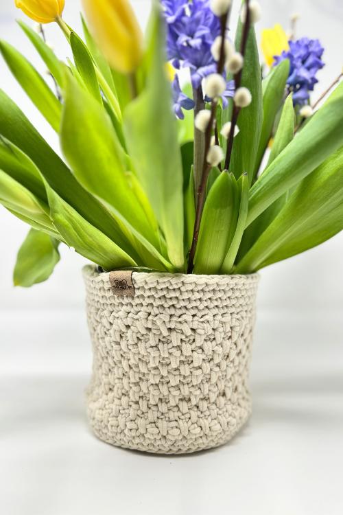 Cream textured crochet planter cover holding tulips, hyacinths and pussy willow stems