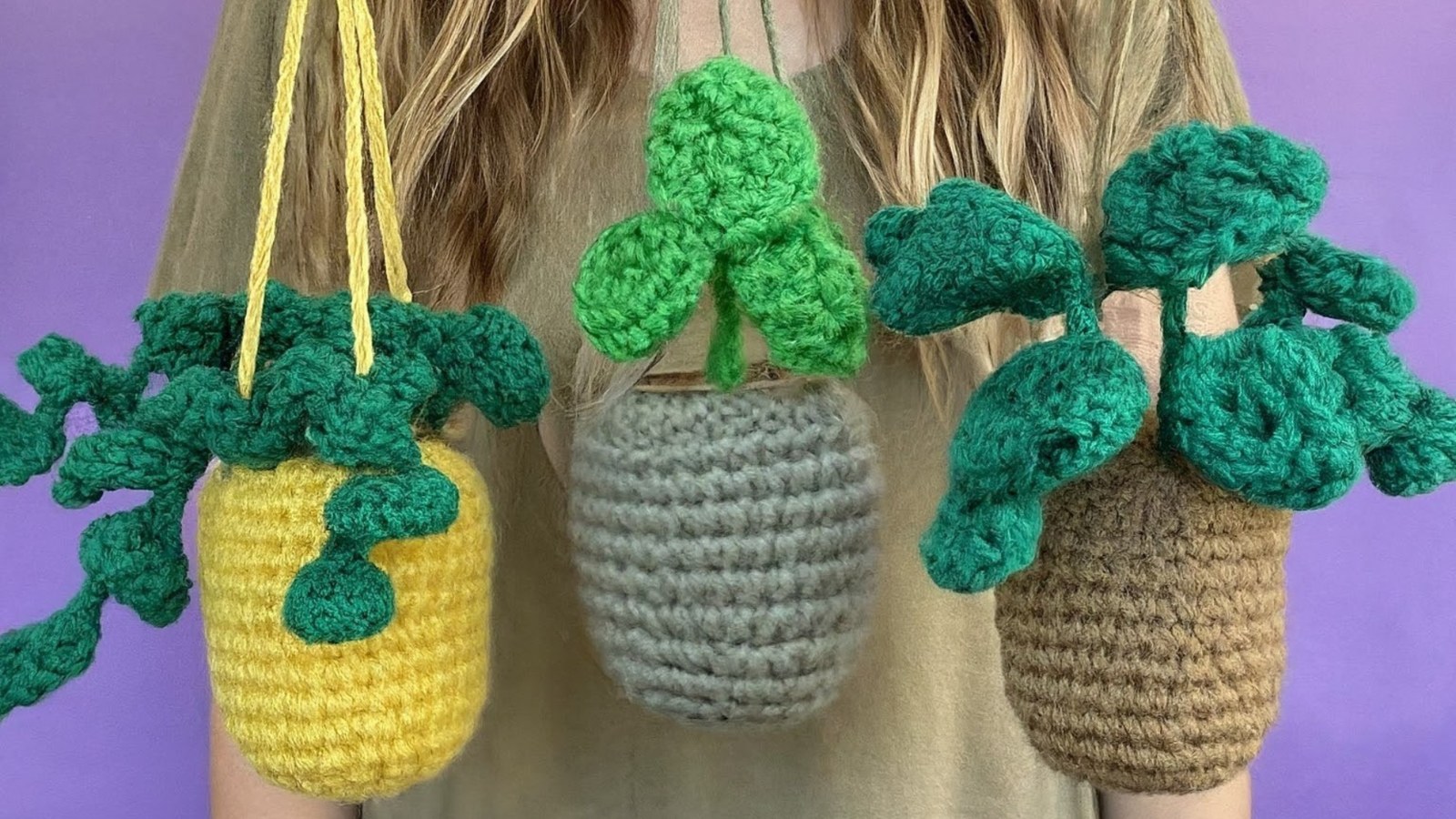 Three crocheted hanging plants in yellow, grey and brown baskets with green pothos and trailing leaves