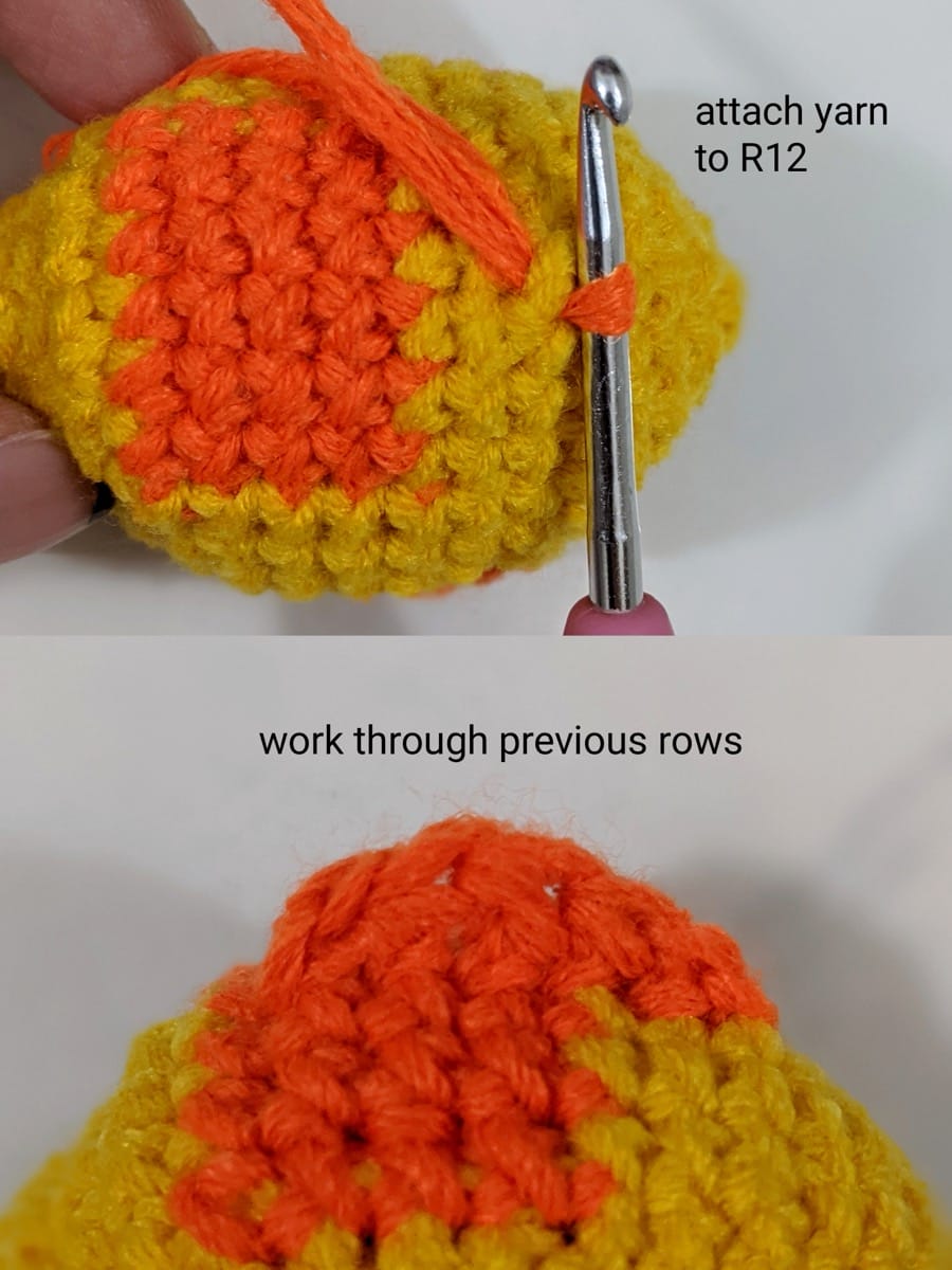 Orange yarn attached at round 12 on top of the goldfish body with a crochet hook, and the finished dorsal fin worked through the previous rows